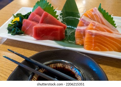 Slices Of Fresh Raw Tuna And Salmon On A White Plate. Traditional Sashimi Dish In Japanese Fish Restaurant In Tokyo.