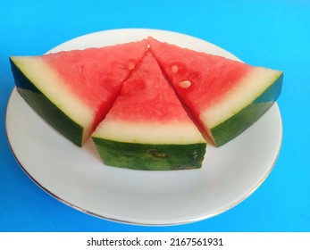 Slices Of Fresh Watermelon On A White Small Plate Isolated On A Light Blue Background