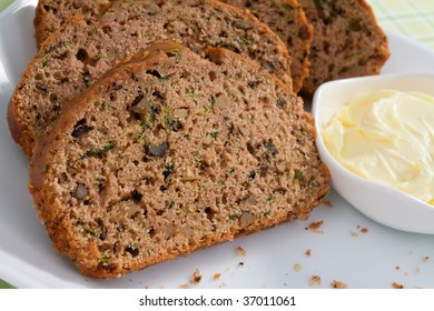 Slices of freshly baked zucchini bread served with butter.