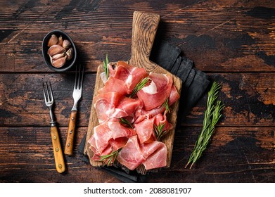 Slices Of Jamon Serrano Ham Or Prosciutto Crudo Parma On Wooden Board With Rosemary. Wooden Background. Top View