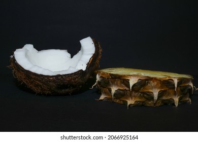 Slices of juicy pineapple and snow-white coconut isolated on a black background. Delicious fruit dessert