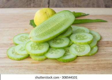 Slices Of Lemon And Cucumber On Wooden Background