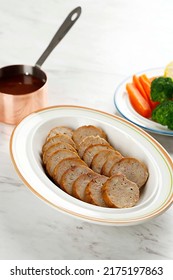 Slices Of Meatloaf With Brown Gravy, Roasted Potatoes, And Mixed Vegetables Served In White Dish On White Background