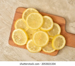 Slices Of Organic Lemon On A Wooden Cutting Board Overhead View