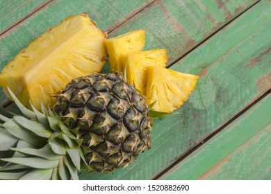 Slices of pineapple on green wood. - Powered by Shutterstock