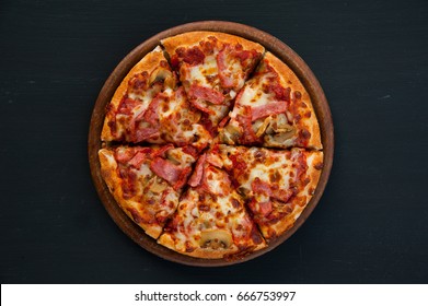 Slices of pizza on rustic wooden tray and dark background - Powered by Shutterstock