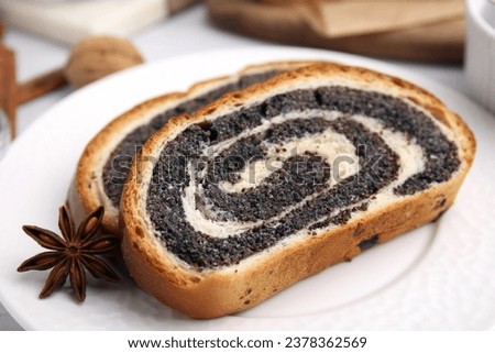 Slices of poppy seed roll and anise star on plate, closeup. Tasty cake