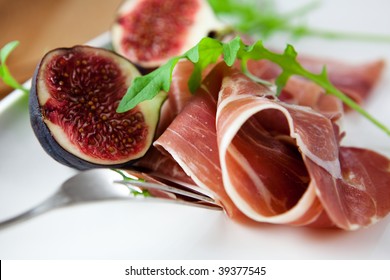 Slices of Prosciutto Prosciutto crudo with figs and rocket on a plate. Tasty appetizer. Food background. White background. Close up.  - Powered by Shutterstock