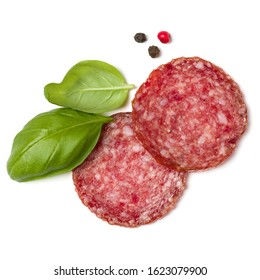 Slices Of Salami Isolated On White Background Closeup. Sausage And Basil Leaves Top View.