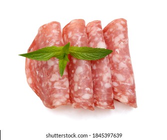 Slices Of Salami Isolated On White Background Closeup. Sausage And Basil Leaves Top View.