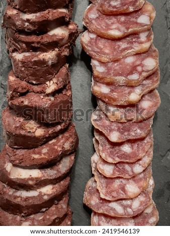 Slices of sausage and meat pudding on a plate, top view