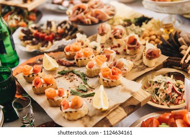 Slices of smoked salmon with butter and white bread on a rustic wooden background. Rich buffet table - Shutterstock ID 1124634161
