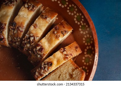 Slices Of Sweet Bread With Pieces Of Walnuts On Top, Over A Mud Or Clay Mexican Plate And A Blue Surface Table, Overhead, Top View Flat Lay Horizontal Macro Photography.