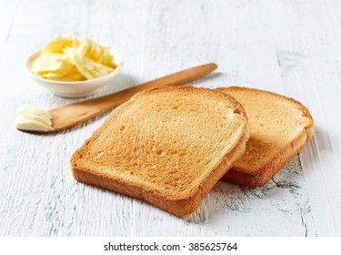 Slices Of Toast Bread And Butter On Wooden Table