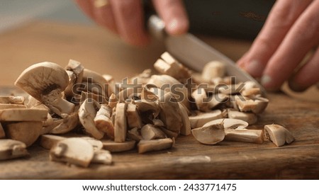 Slicing Mushroom on Wooden Board. Close-up, shallow dof.