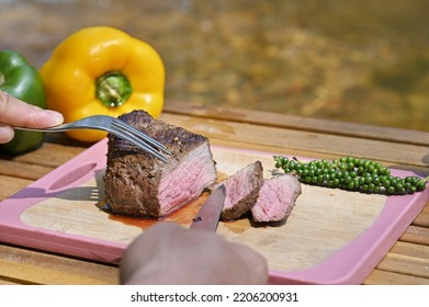 Slicing Rare Fillet Mignon Steak On Wood Board