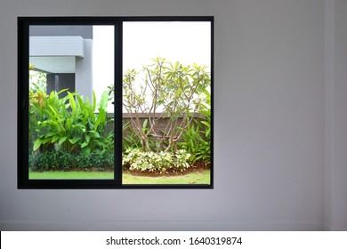 slide glass window on white wall interior in modern empty room with small garden landscaping outside a new house