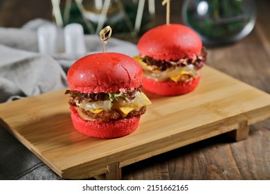 Slider chicken burger with cheese and pickles close up red color butter bread