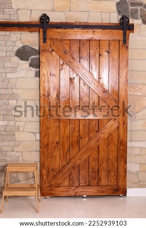 Sliding barn wooden door in indoors. Sliding old Barn Door in modern room. Rustic farm wood sliding barn style door at home. 
