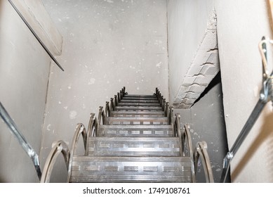 Sliding Metal Stairs To The Attic In The Ceiling, An Open Flap And A Modern Look. View From The Top Of The Stairs Down.