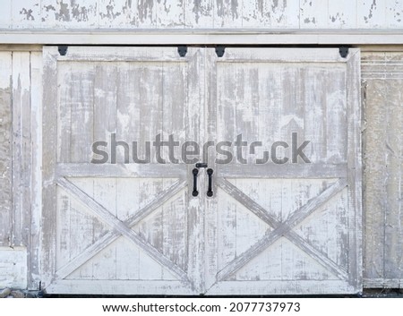 Sliding rustic barn or stable doors. White barn wood with rustic finish.