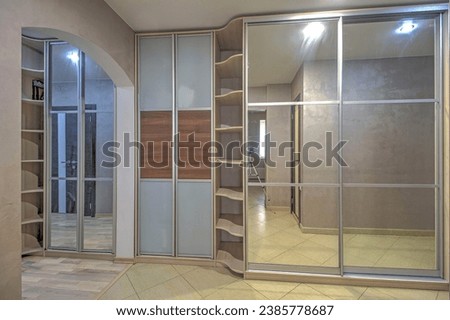 Sliding wardrobe with a mirror in an empty corridor.
