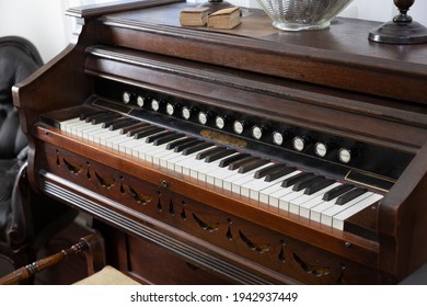 A Slight Downward, Close Up View, of an Antique Pump Organ with Stops Pull Knobs
