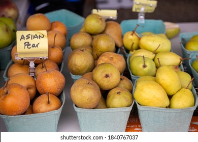 A Slight Elevated View Of Three Rows Of Cartons Of An Assortment Of Pears On A Farmstand Table
