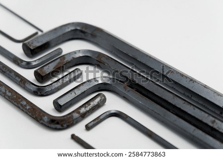 slightly angled view of a set of Allen keys (also known as hex keys) lying on a white surface.