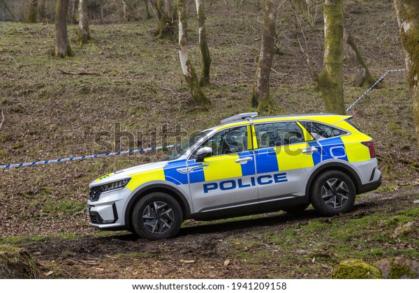A slightly muddy British police car at a crime scene\
in Wales, UK\
