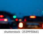 A slightly unclear photograph shows various cars navigating their way along a highway during the nighttime hours, illuminated by streetlights