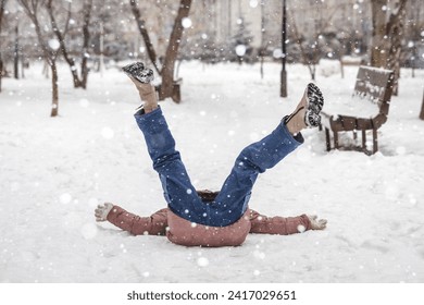 Sliipery Road in Winter. Fall Girl Teenager Slipped on Ice Road and Lying on Snow Road with Legs up. Insurance Accidents and Injuries on Road Outside. - Powered by Shutterstock