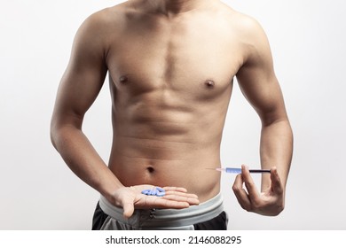 slim athletic man injecting anabolic steroid and holding supplement diet pills on hand palm - Powered by Shutterstock