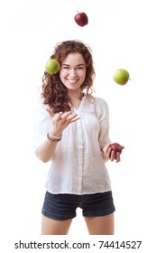 Slim beautiful woman juggling with red and green apples on white background