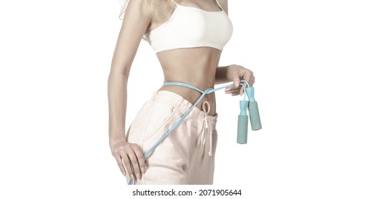 Slim body, jump rope. Girl with perfect waist with a jump rope in hands. Athletic slim woman measuring her waist by measure tape after diet. Fit fitness girl measuring her waistline with measure tape.