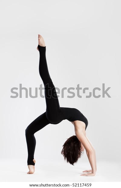 Slim dancer in\
yoga pose bending over\
backwards