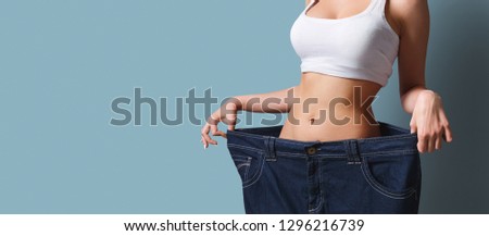 Slim girl in too big pants. The Biggest Loser concept
