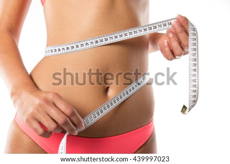 A slim girl measuring her waist, close-up.