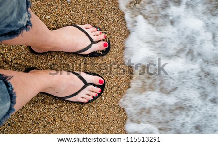 slim girl's legs on sandy beach