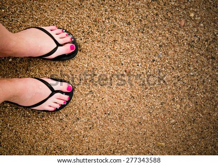 slim girl's legs on sandy beach 