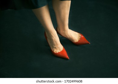 Slim Mature Woman Wearing Black Cocktail Dress And Red Shoes