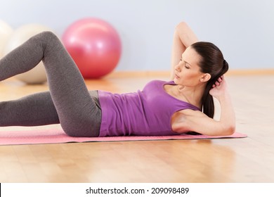 slim mid woman do her fitness exercises. pretty girl working out on floor and holding hands behind - Powered by Shutterstock