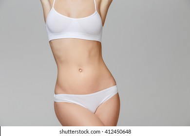 Slim tanned woman's body Isolated over gray background