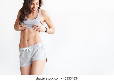 Slim Tanned Woman's Body Over White Background. Perfect Six Pack Abs With Copy Space