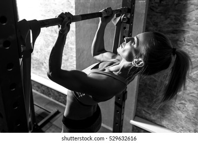 Slim well built woman holding a horizontal bar - Powered by Shutterstock