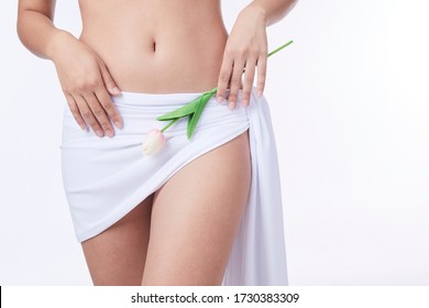 Slim Woman , Holding A White Flower In Her Hands, Close-up. Gynaecology, Menstruation, The Concept Of Genital Health