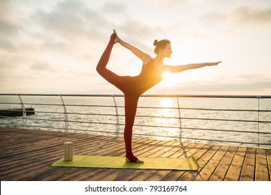 Slim Woman Standing In Yoga Asana On Sunrise By The Sea, Morning Exercises, Healthy Body