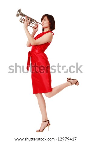 Slim woman in stylish red dress hopping on white background and playing the trumpet