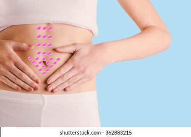 Slim woman touching her belly against blue background