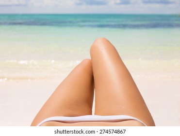 Slim Woman's Legs On The Beach